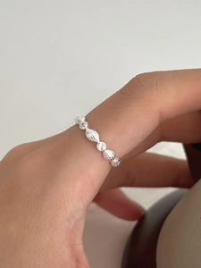 Detailed side view of S925 silver ring featuring round zircons and textured olive segments