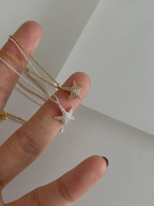 Detailed view of silver and gold starfish pendants with cubic zirconia micro-pave setting