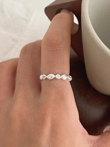 Macro shot of silver S925 wavy band ring with pavé cubic zirconia on model's hand