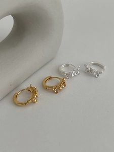 Détail de boucles d'oreilles créoles en argent 925 avec fleurs en finitions or et argent