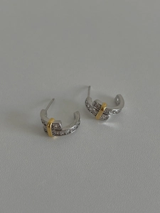 Close-up of 925 sterling silver hoop earrings with sparkling zircon pave and gold accents