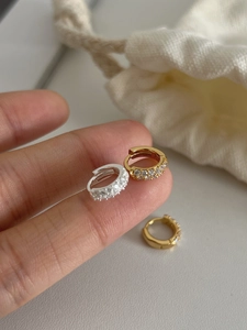 Vue détaillée des boucles d'oreilles huggie en argent 925 serties de zircons brillants