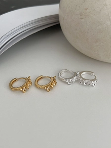 Gros plan sur boucles d'oreilles fleur en argent 925 plaqué or et platine avec zircon