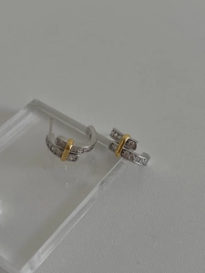 Macro detail of 925 sterling silver C-shape stud earrings with gold plating and zircons