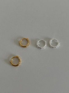 Détail de boucles d'oreilles huggie en argent 925 avec zircons en finitions or et argent