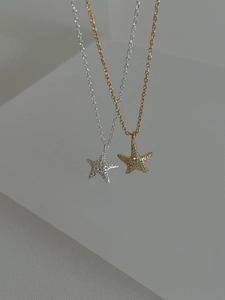Detail of 925 silver and gold starfish pendants with sparkling zircon pavé stones