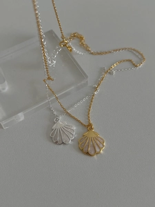 Détail de pendentifs coquillages dorés et argentés avec incrustation nacrée sur chaînes en O