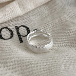 Elegante anello aperto in argento sterling S925 con texture spazzolata e bordi perlati