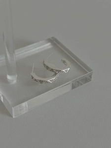 Detailed macro view of 925 silver geometric hoop earrings with pavé diamond lattice design