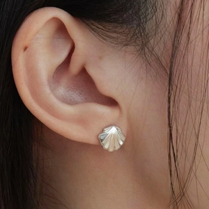 Gros plan de boucles d'oreilles minimalistes en forme de coquille avec nacre blanche