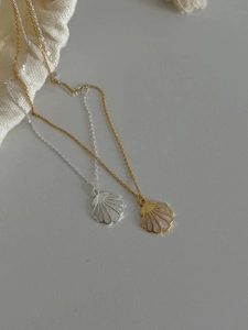 Détail de colliers avec pendentifs coquillage en or et argent avec nacre irisée