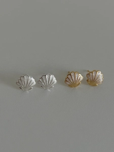 Vue détaillée de boucles d'oreilles étoiles de mer en argent et or avec textures coquillage