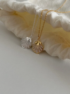 Vue détaillée des colliers pendentif coquillage en or et argent avec nacre rose