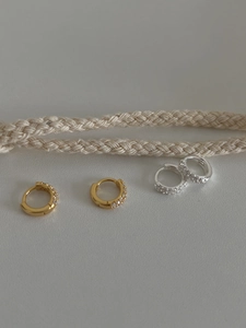 Détail de boucles d'oreilles huggie or et argent avec pavé de zircons blancs fins