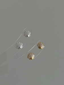 Détail des boucles d'oreilles coquillage en or et argent avec incrustation de nacre fine