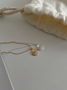 Vue macro de pendentifs coquillage en or et argent avec nacre sur des chaînes fines