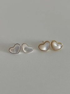 Detailed close-up of heart-shaped mother-of-pearl stud earrings with gold and silver borders