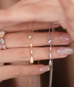 Dettagli di collane a goccia vintage in oro e argento con anello floreale in turchese