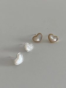 Detail of heart stud earrings set featuring iridescent mother of pearl and metallic frames