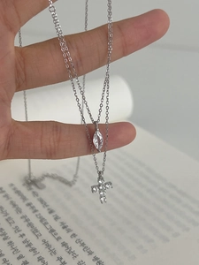 Macro shot of S925 silver double layer necklace with cross and marquise stone detail
