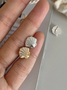 Gros plan de boucles d'oreilles en forme de coquillage en or et argent avec nacre