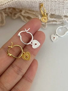 Primo piano del marchio S925 su orecchini a cuore in argento sterling oro e argento
