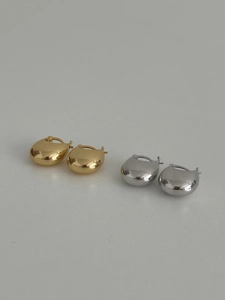 Detailed view of polished gold and silver water drop earrings in a minimalist style