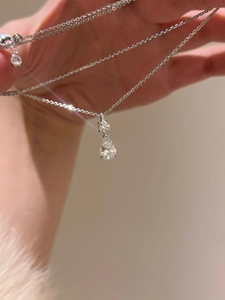 Detailed close-up of a pear-cut teardrop pendant on a delicate silver necklace chain