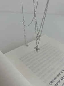 Macro view of S925 silver double-layer necklace with cross and marquise drop pendants
