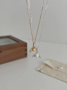 Close-up of S925 sterling silver fishtail necklaces with pearls and shimmering zircons