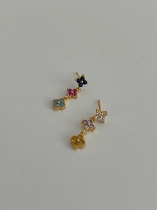 Détail des boucles d'oreilles trèfle multicolores avec cristaux scintillants incrustés
