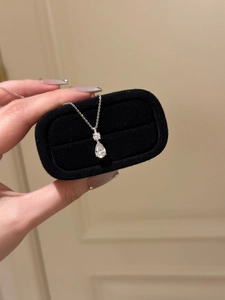 Detailed close-up of a pear-cut teardrop necklace presented in a black velvet jewelry box
