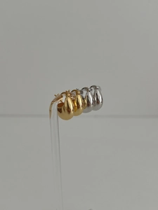 Macro shot of silver and gold drop earrings with polished metallic mirror finish
