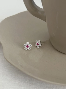 Macro shot of silver plum blossom stud earrings with white zircon and pink center stone