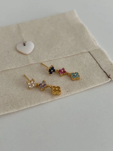 Détail de boucles d'oreilles trèfle à quatre feuilles dorées avec émail multicolore