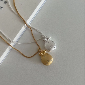 Halsketten mit Glücksbeuteln in Silber und Gold, mattiert mit Kristallen auf Buch