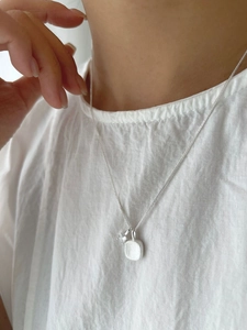 Detail of S925 silver necklace featuring a brushed square pendant and a zircon stone