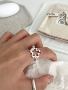 Detail of S925 silver hollow flower ring featuring hammer texture and pink zircon stone
