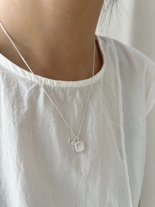 Macro shot of S925 silver square pendant with zircon inlay on a delicate chain necklace