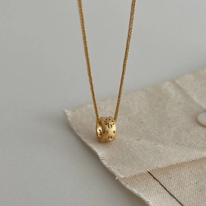 Elegant gold S925 silver cylinder necklace featuring starburst engraving and a tiny diamond