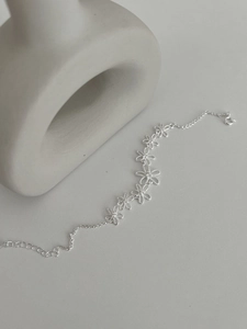 Detailed macro of S925 silver bracelet featuring seven hollow daisy floral link designs