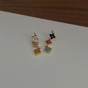 Boucles d'oreilles trèfle asymétriques dorées avec émail coloré et petits cristaux