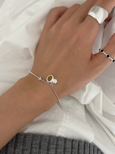 Detail of S925 silver chain bracelet with tiger eye stone gourd pendant on wrist