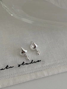 Detailed view of polished S925 sterling silver drop earrings on textured linen background