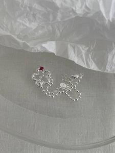Dettaglio del bracciale quadrifoglio in argento S925 con cuore rosso e catena a sfere