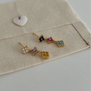 Boucles d'oreilles trèfle de luxe à la française avec émail coloré sur sac beige