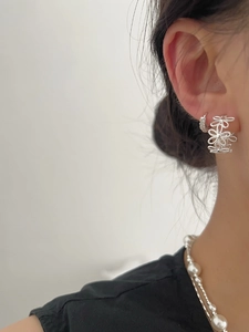 Detail of S925 silver lace flower earring and small pavé stud on model with pearls