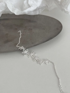 Macro detail of silver daisy flower bracelet with twisted texture and zircon inlay