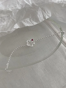 Dettaglio del bracciale in argento S925 con ciondolo a quadrifoglio e piccolo cuore rosso