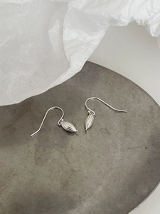 Macro detail of S925 sterling silver shell earrings with striped olive drop on grey stone